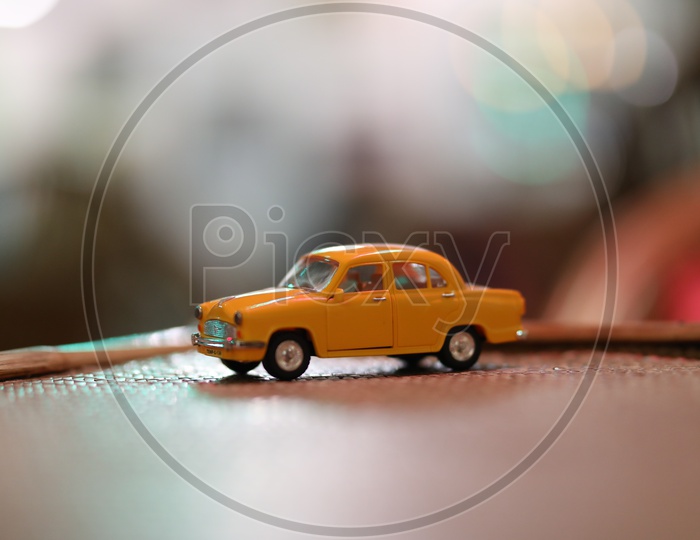 Yellow Car Taxi Miniature Over a Light Bokeh Background