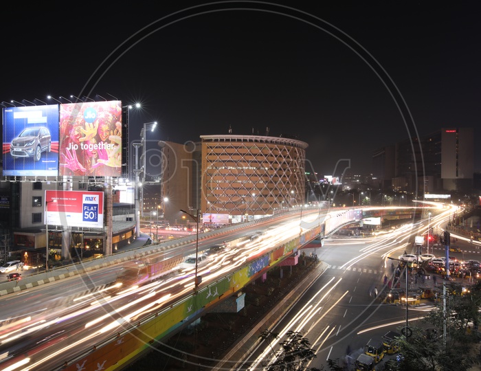 Long Exposure Shot Of Fast Moving Vehicles On Flyover roads And At Hi-Tech City Traffic Signal With Cyber towers In Background