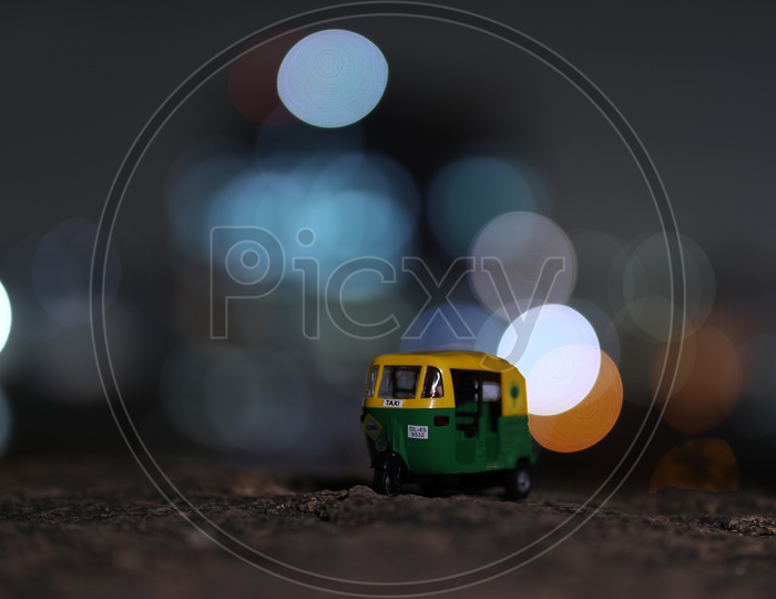 CNG  Auto Green Auto Miniature With City Scape Light Bokeh Background