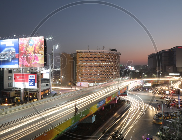 Long exposure   Shot of Fast Moving Vehicles At Hi-tech City Flyover Signal With  Cyber Tower  In Background