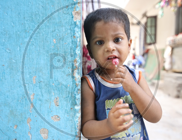 Little Kid eating Lollipop in a Street