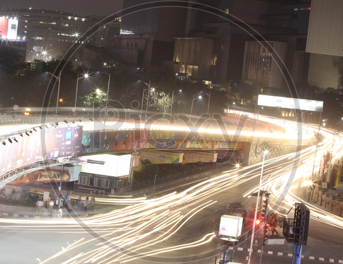Long Exposure Shot Of  Moving Vehicles At Hi-tech Cit y Traffic  Signal And flyover