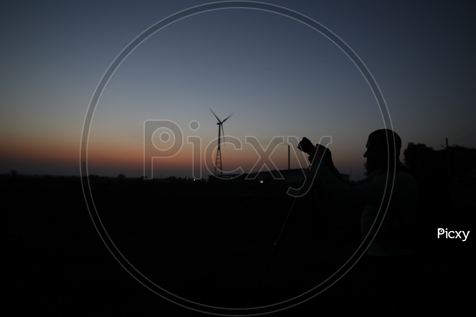 Silhouette Of a Photographer With Wind Mills In Background