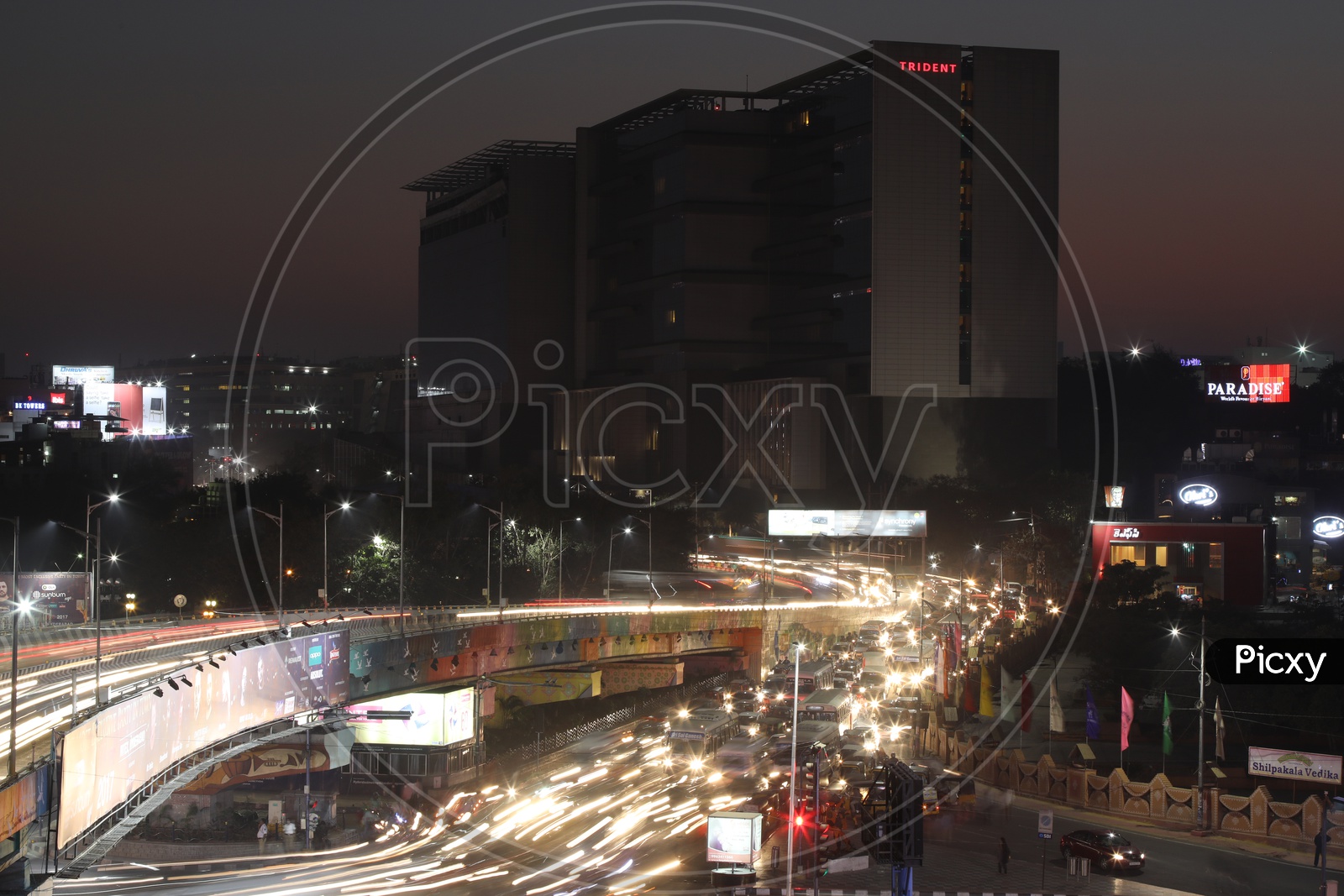 Long exposure   Shot of Fast Moving Vehicles At Hitech City Flyover Signal With Trident Hotel In Background