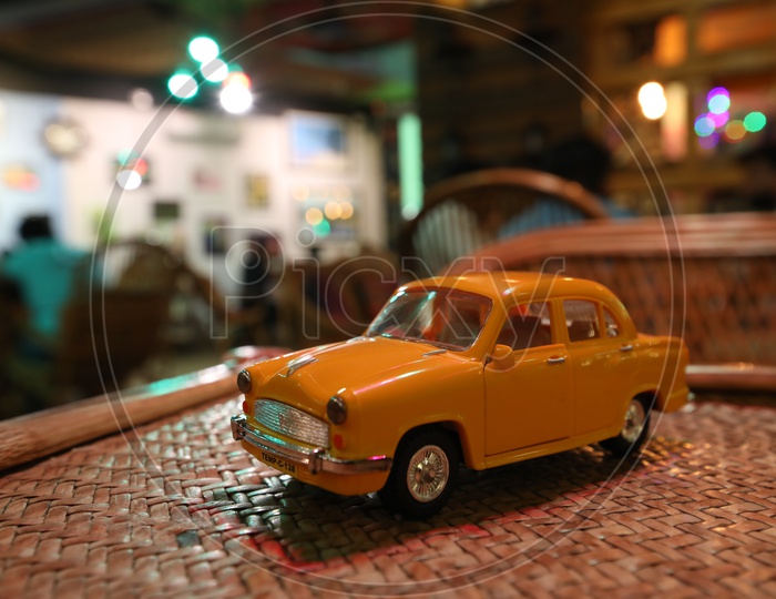 Yellow Car Taxi Miniature Over a Light Bokeh Background