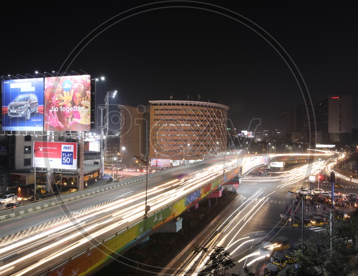 Long Exposure Shot Of Fast Moving Vehicles On Flyover roads And At Hi-Tech City Traffic Signal With Cyber towers In Background