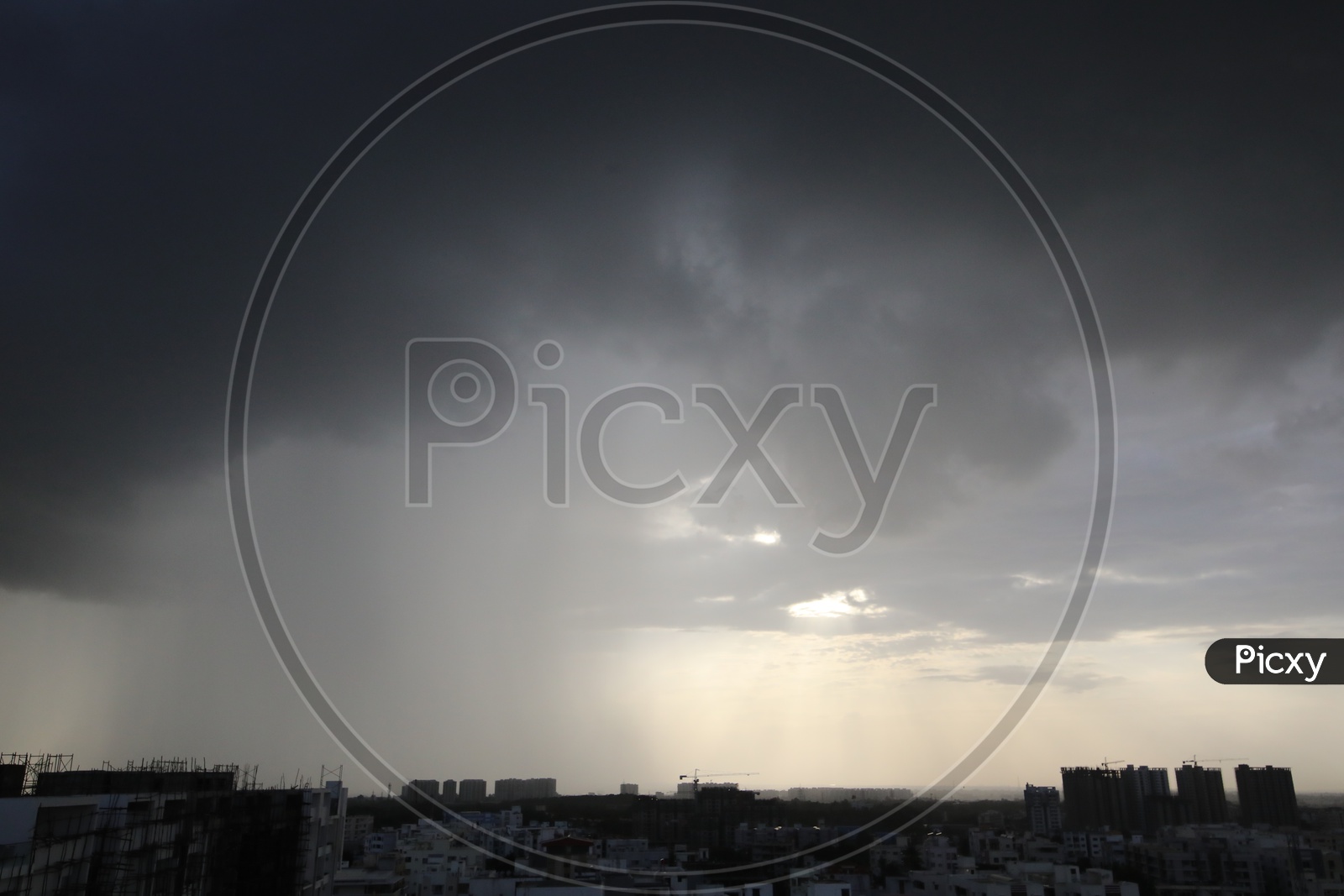 Dark Clouds Over A City Scape  With High Rise Apartments