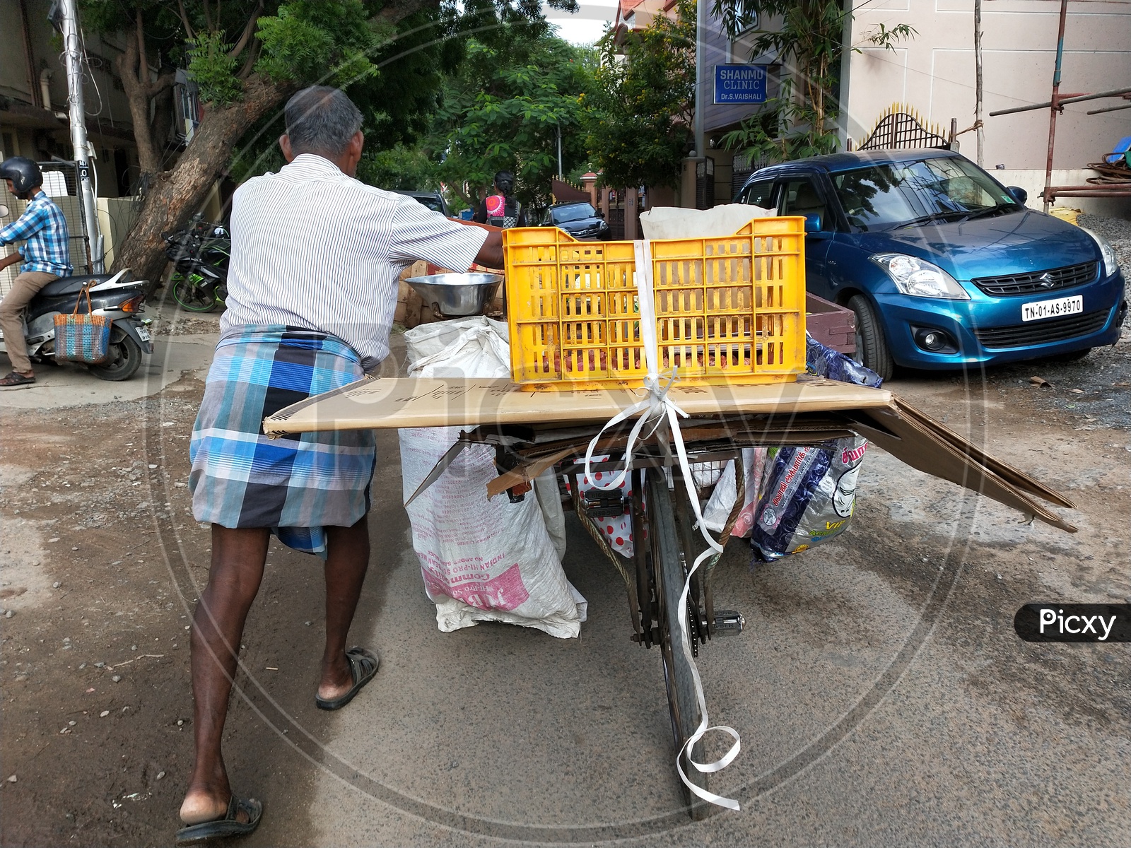 Vendor collecting recyclable sheets and goods by travelling on bicycle