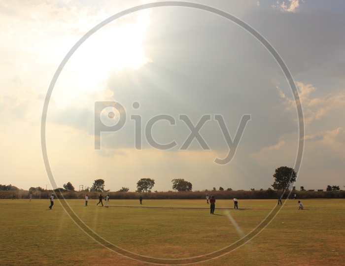 Indian Men Playing Cricket in a College Ground