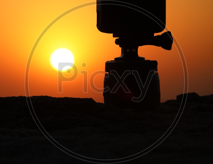Silhouette Of Gopro Action Camera With Sunset Sun In Background
