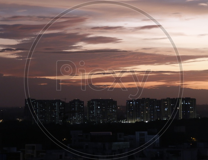 City Scape With High Rise Building And Apartments Over Sunset Sky