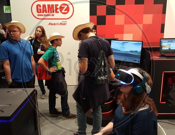 Young Woman using Virtual Reality Headset and Kids playing games at GameZ Stall