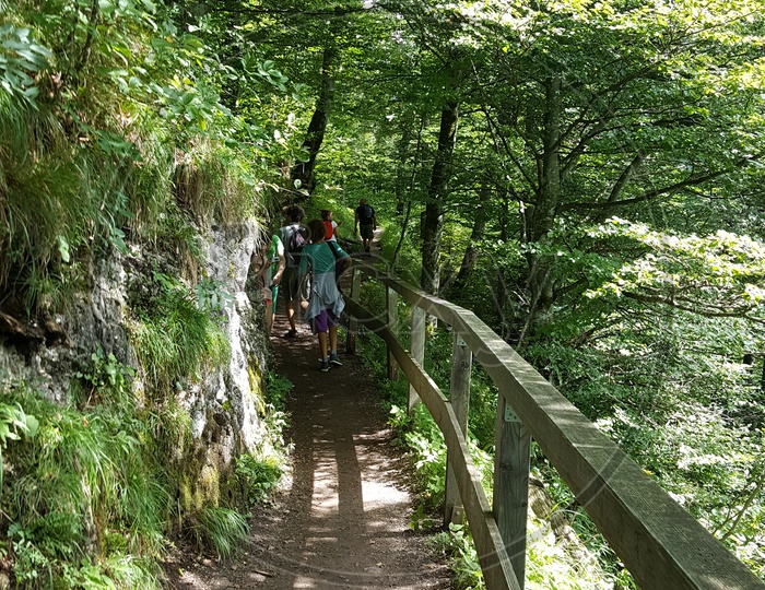 Tourists walking along narrow path in Mountains