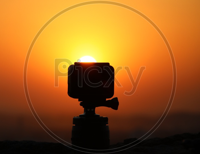 Silhouette Of Gopro Action Camera With Sunset Sun In Background