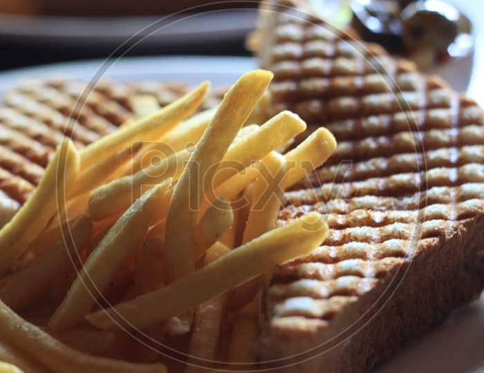 Grilled Sandwich With French fries  in a Restaurant Table