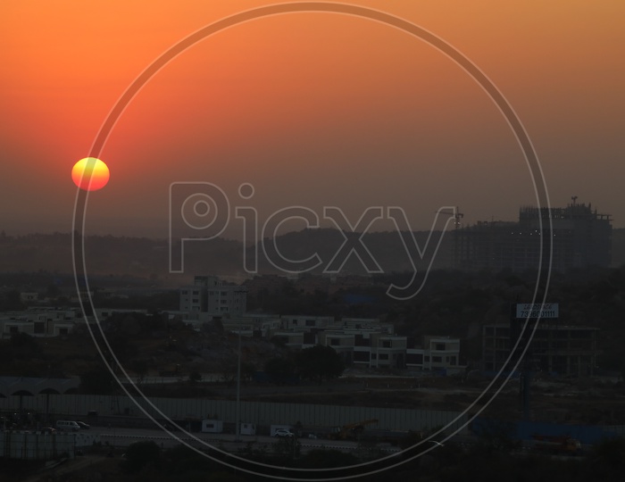 City Scape With High Rise Under Construction Buildings  With a Sunset Sun In Sky As a Background