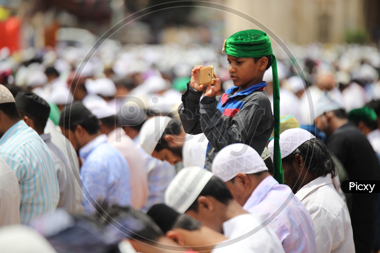 A Muslim Boy Wearing Green Turban  And Capturing Ramdan Ramzan Prayers At Jama Masjid