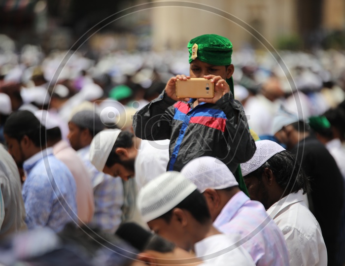 A Muslim Boy Wearing Green Turban  And Capturing Ramdan Ramzan Prayers At Jama Masjid