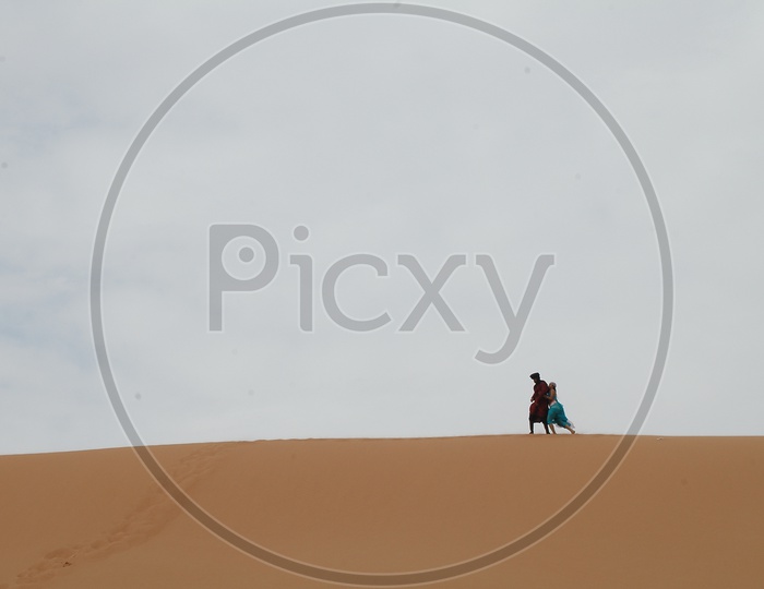 A Couple on Sand Dunes of Desert