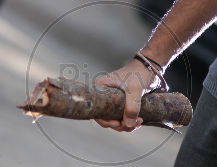 Man Holding Wooden Stick In Hand Closeup