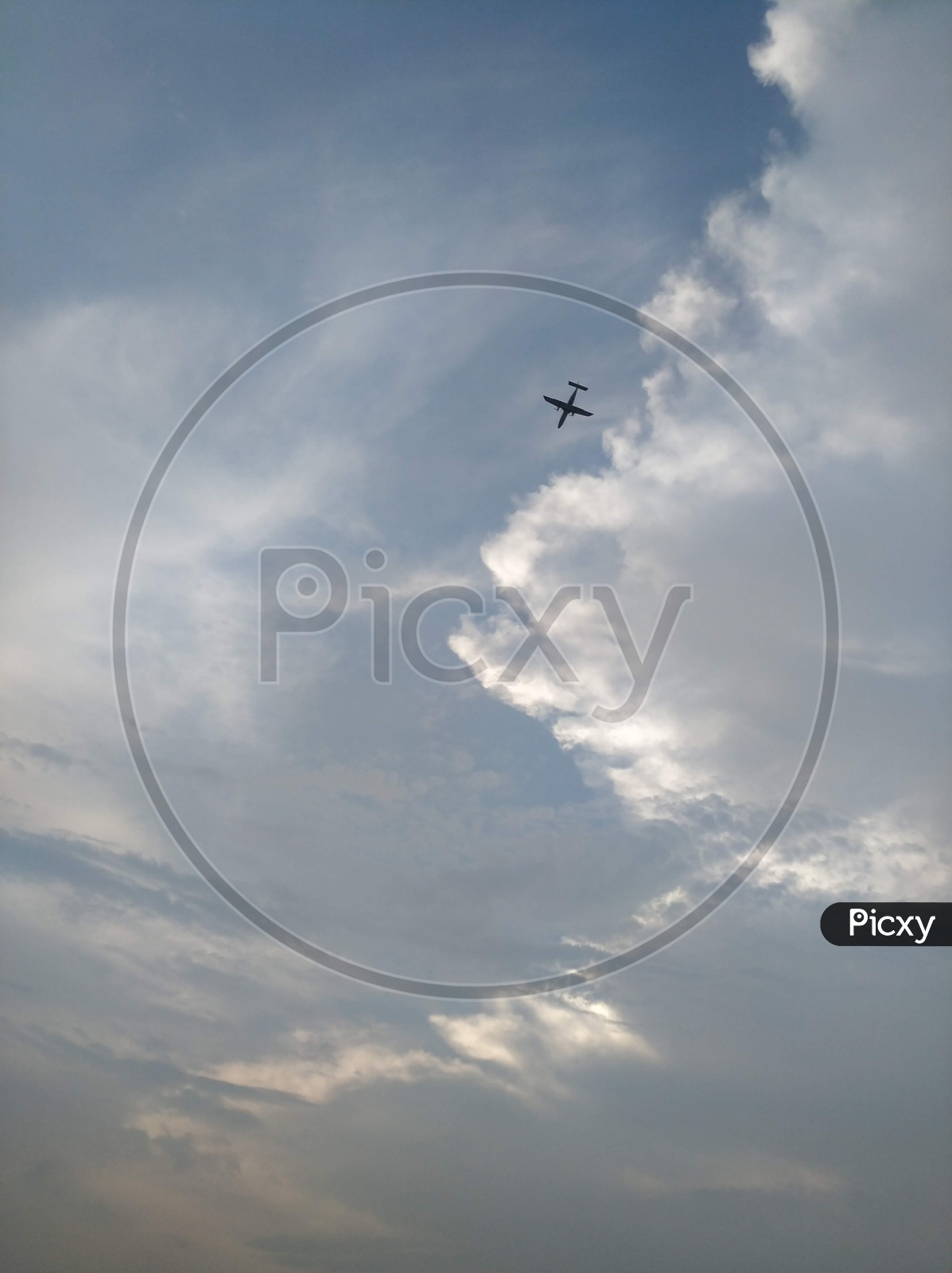 Flight Flying In Sky Over  Silver Clouds Backdrop