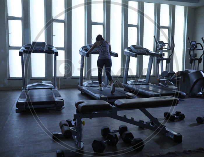 Silhouette Of Woman On Thread Mill In a Gym