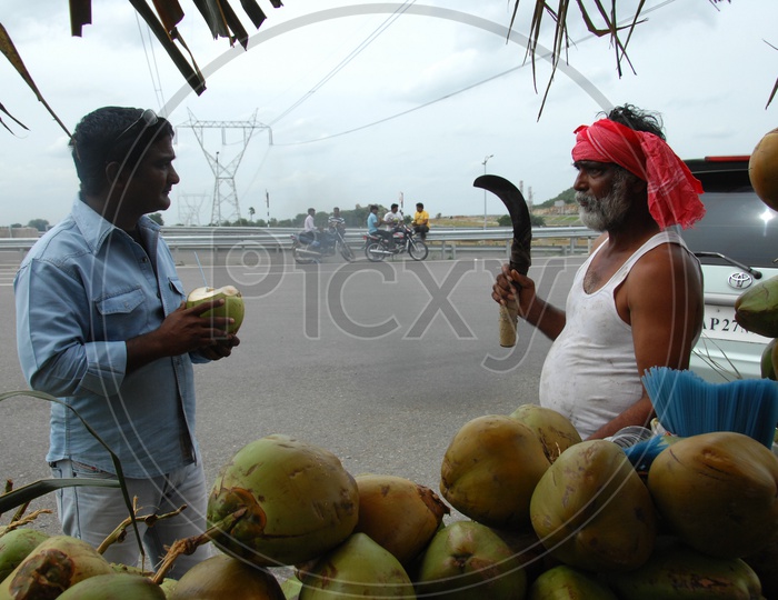 Coconut Vendor Chopping Coconut At a Highway Road Side