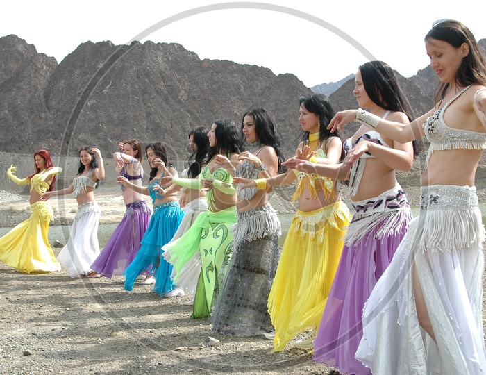 Dancers belly Dancing At Sedimentary Rock  Dunes  For a movie Shooting