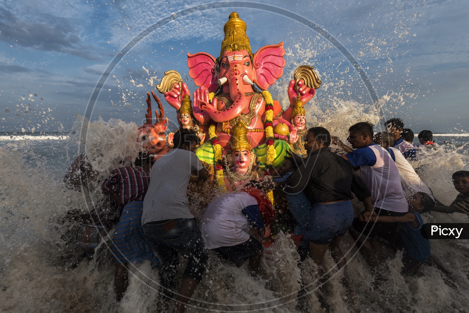 Big wave splashing against the Ganesh idol while immersing in the sea.