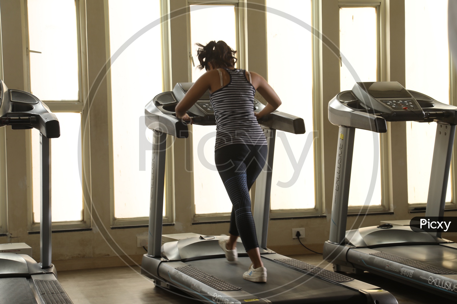 Silhouette Of Woman On Thread Mill In a Gym