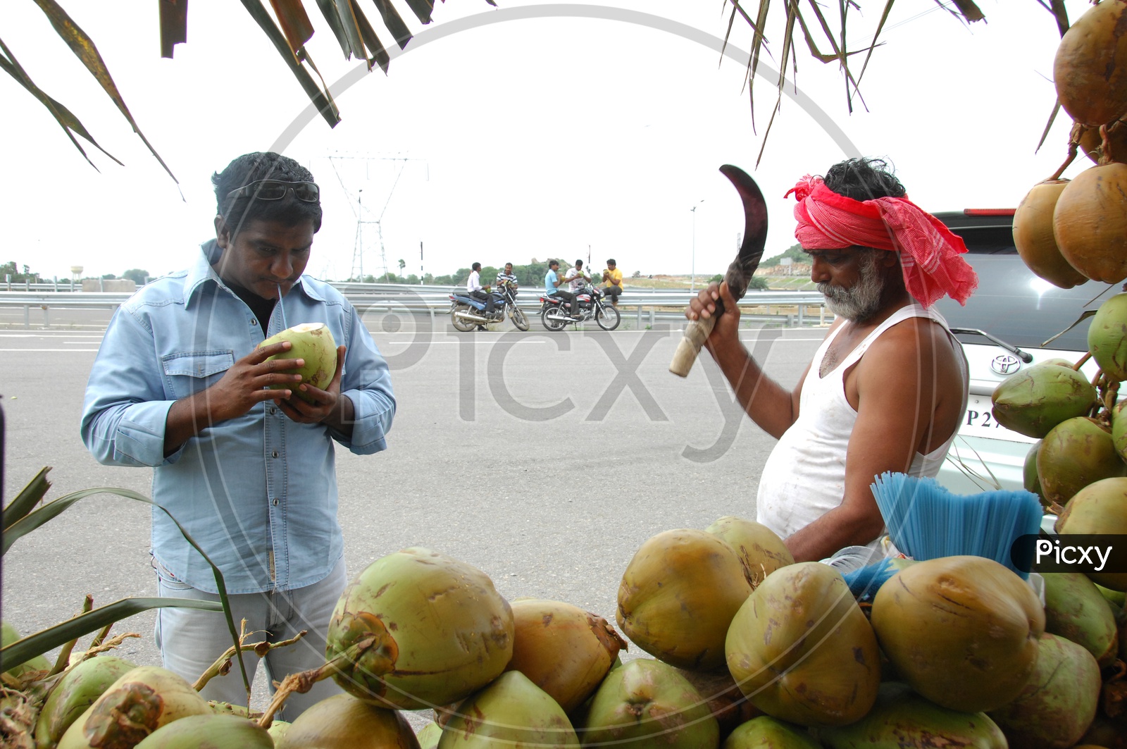 Coconut Vendor Chopping Coconut At a Highway Road Side