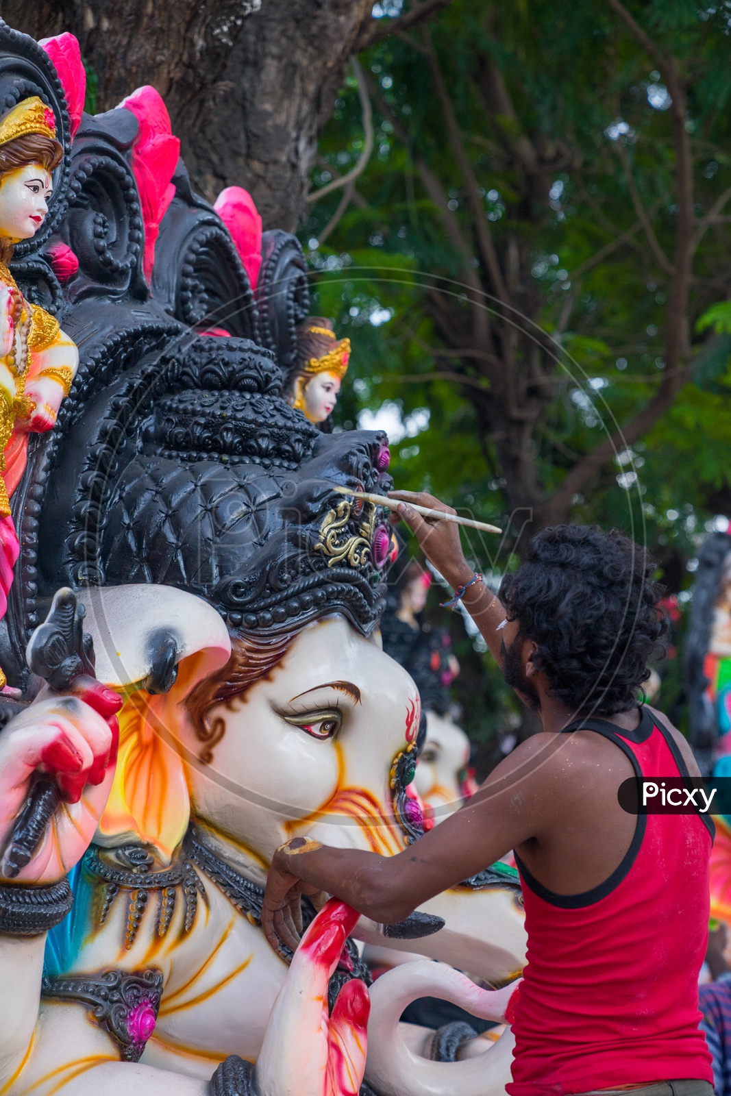 A person giving the final touches to the ganesha idol