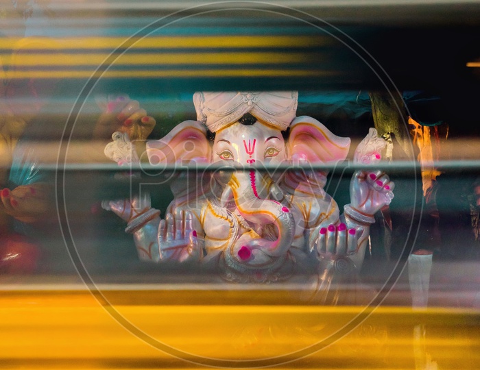 Lord ganesha framed from the mirrors of a moving school van