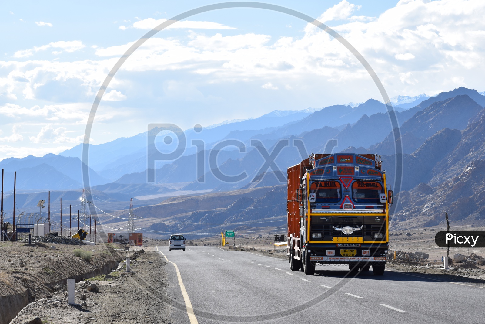 Lorry passing on the highway with the backdrop of Himalayas