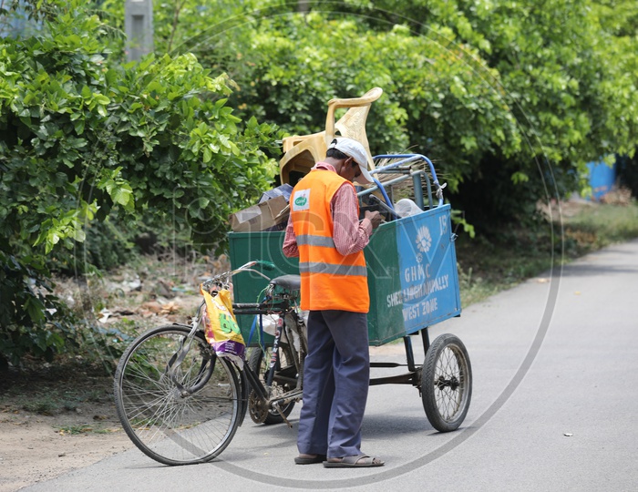 Sanitary Workers Or Municipality Workers Carrying Trash Or Garbage  in Rickshaws on Streets