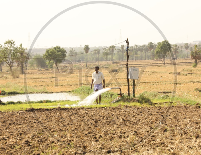Farmers Watering The Agricultural Lands or Farm Lands With Motor Pumps In Rural Villages