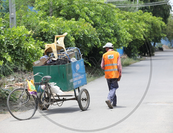 Sanitary Workers Or Municipality Workers Carrying Trash Or Garbage  in Rickshaws on Streets
