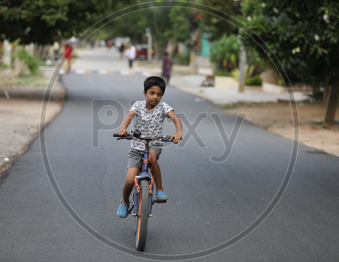Indian Urban Village Kids Or Children Riding Bicycles Or Cycles on The Roads