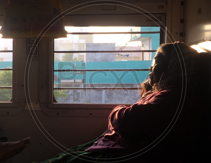An Old Woman Siting At a Window In a Train