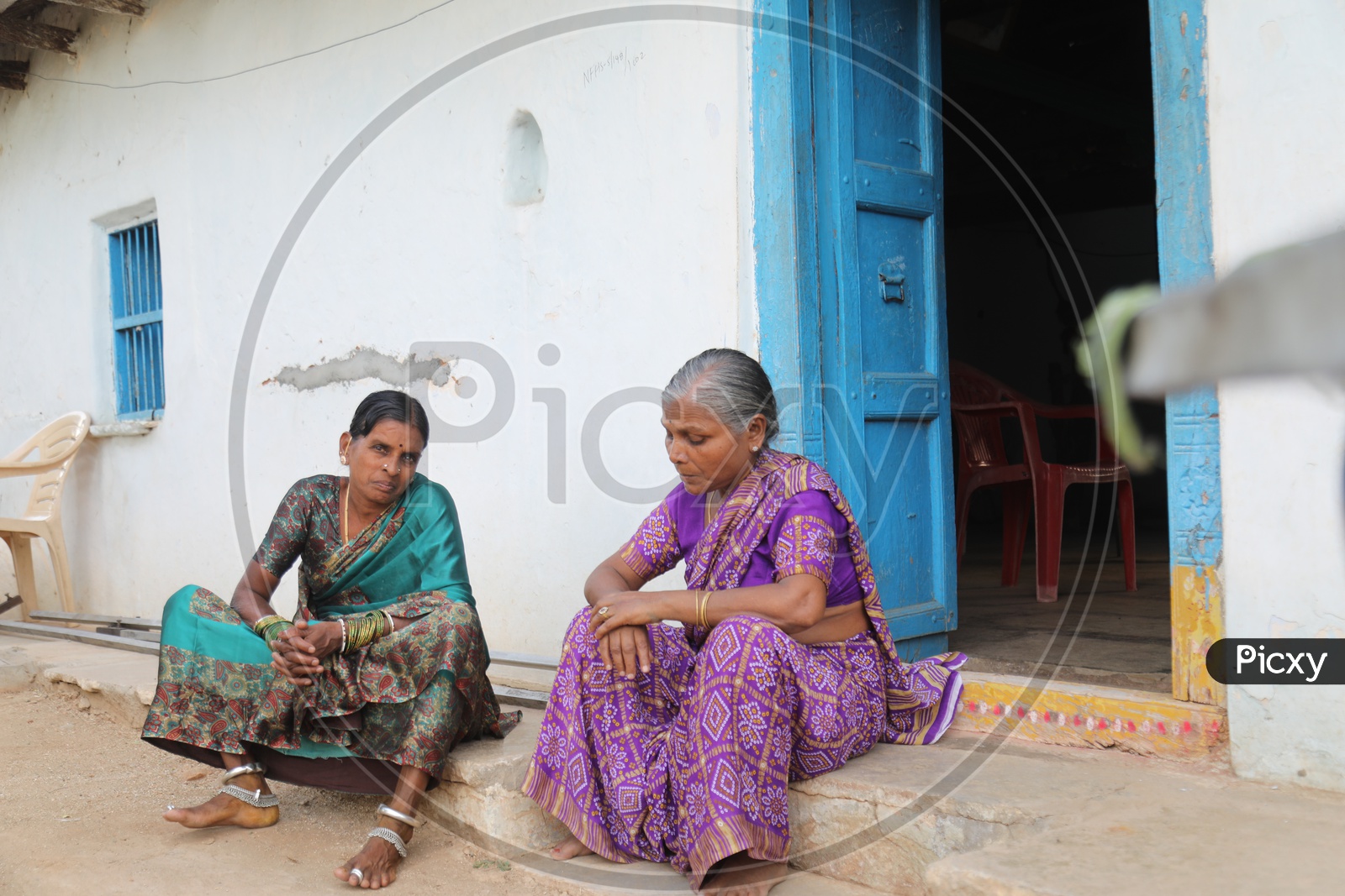 Indian Rural Village Woman  Sitting And Chit Chatting With Each Other At a house Door Step Or Entrance