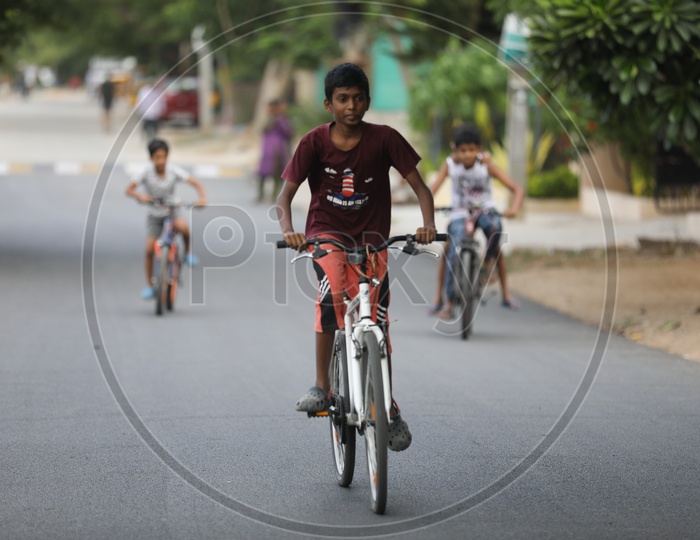 Indian Rural Village Kids Or Children Riding Bicycles Or Cycles on The Roads