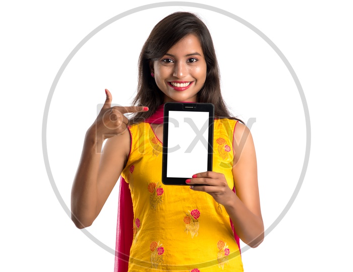 Young Indian Girl or Woman Showing Tab Or Tablet Gadget Empty Screen  With an Expression On an Isolated White Background