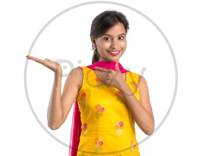 Young Indian Girl Or Woman Smiling Happily And Showing Space  On an Isolated White Background