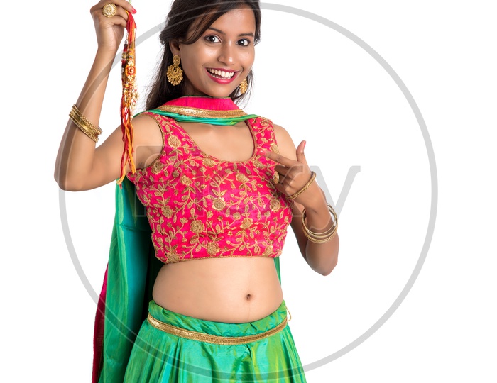 Young Indian Girl Or Woman Or Sister Holding Rakhi  With Expressions On an Isolated White Background