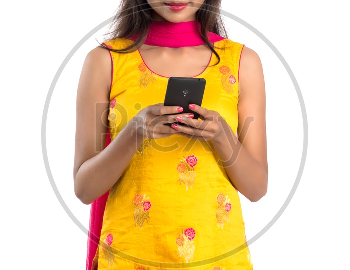Young Indian Girl or Woman Using  Smartphone  or Mobile  With an Expression On an Isolated White Background