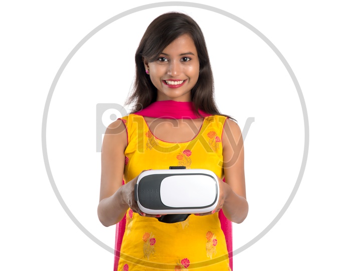 Young Indian Woman Or Girl Holding and Posing With a VR Headset Or Virtual reality Glasses On an Isolated White Background