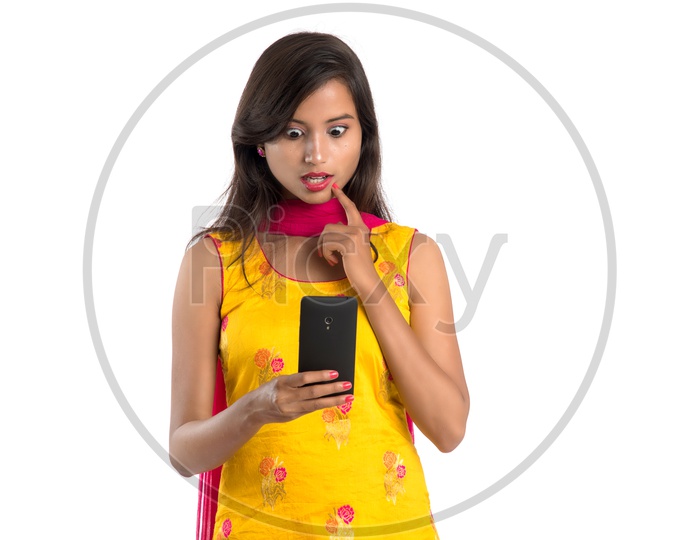 Young Indian Girl or Woman Using  Smartphone  or Mobile  With an Expression On an Isolated White Background