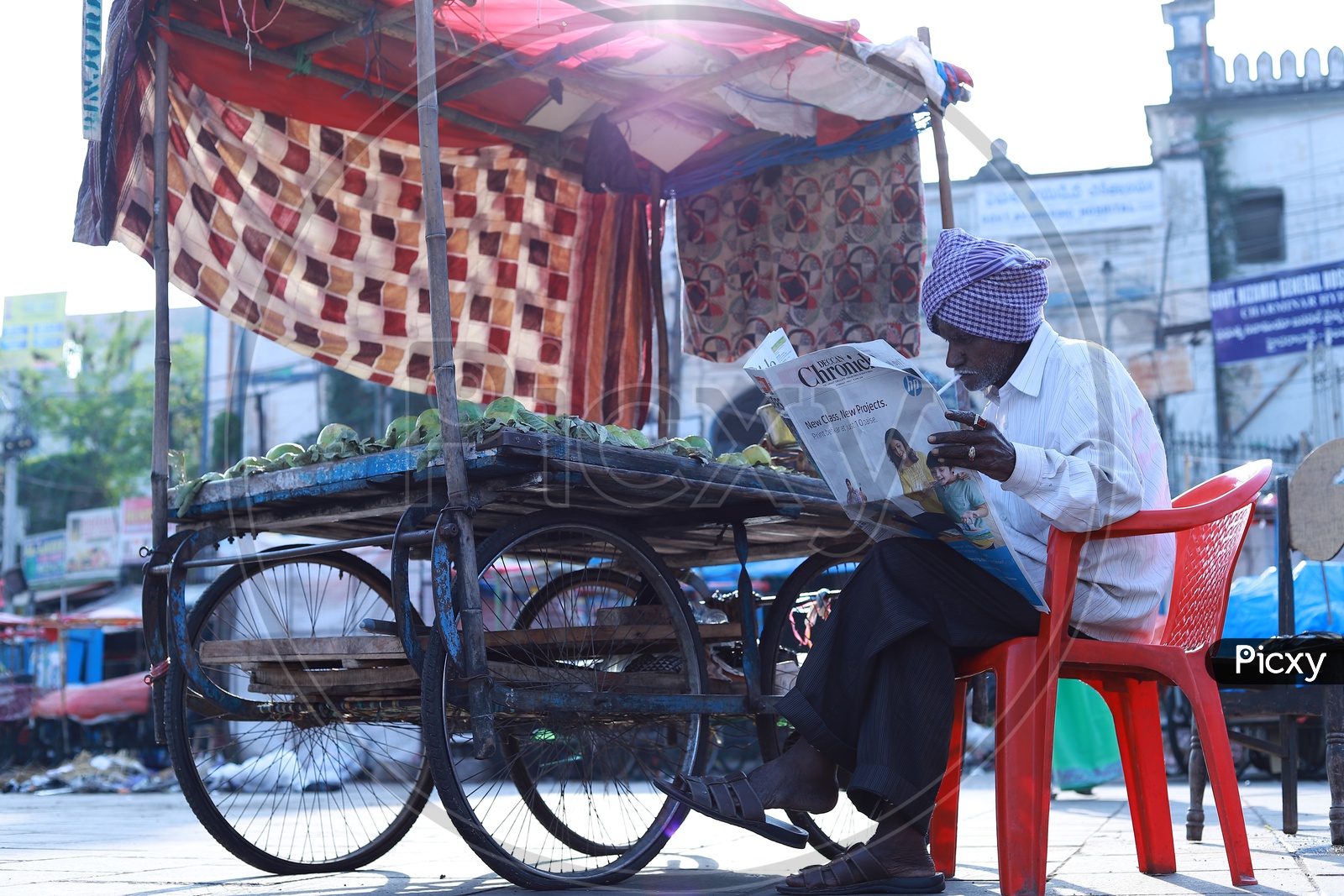 An old man reading Deccan chronicle news paper