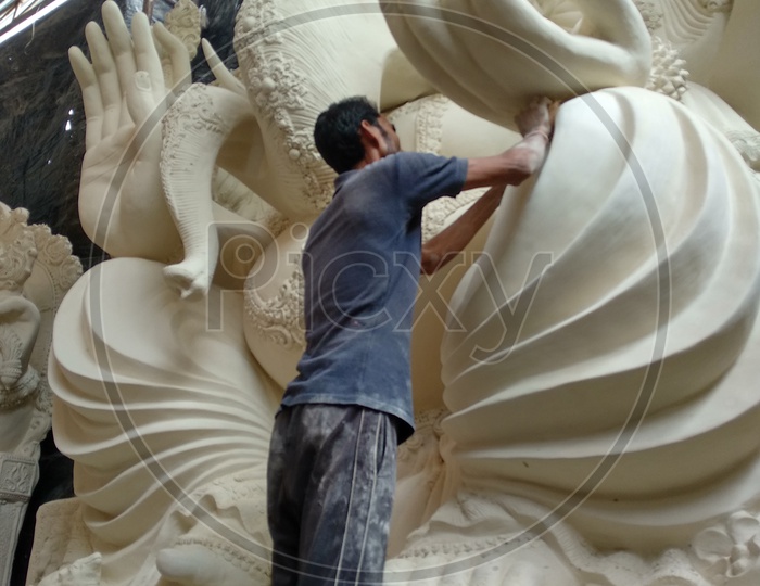 Prepartion of Ganesh Idol for Ganesh Chathurthi. A man cleaning the dust and doing final finishing for Idol