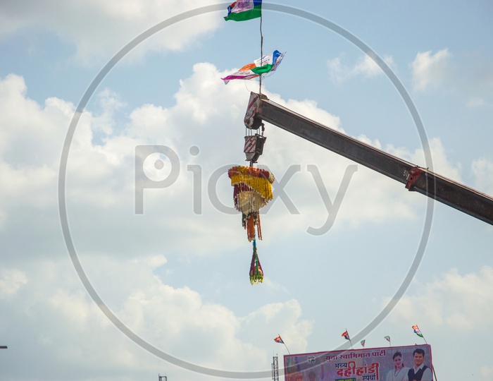 Dahi Handi Or Vutti  Hanging  For Gokul Or Sri Krishna Astami Festival With Pot Filled With Curd And Decorated With Flowers